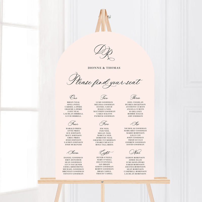 Traditional calligraphy wedding seating chart or guest name plan with monogram of bride and grooms initials. Laser cut to arch shape.
