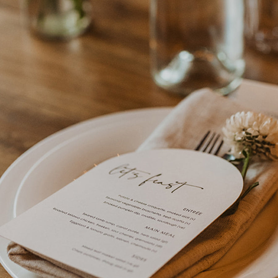 Arch shape wedding menu is black and white with guest names printed and Lets Feast heading. Printed in Australia.