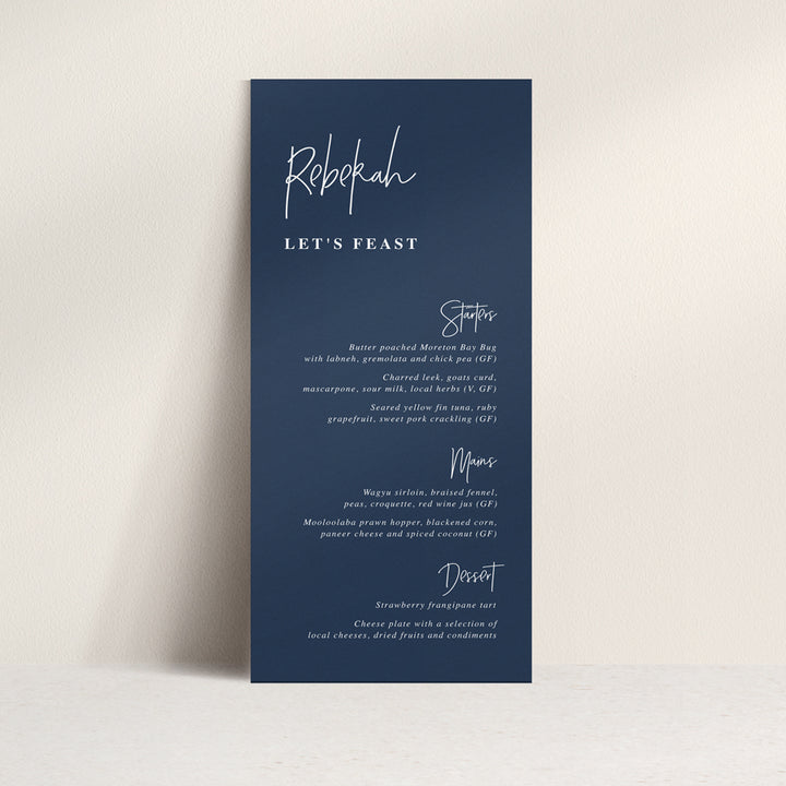 Modern wedding menu on navy blue cardstock with white ink. Guest names on each menu and lets feast for heading.