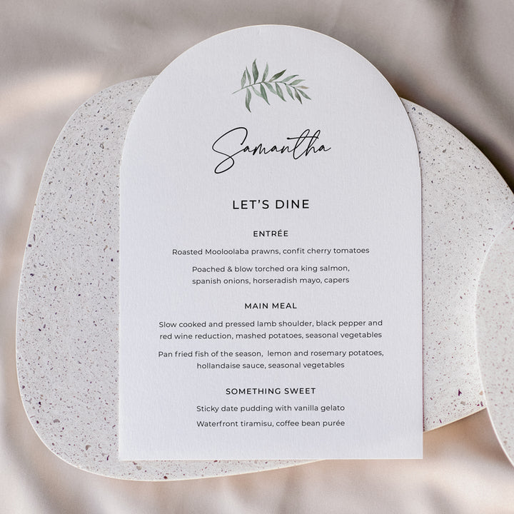 Arch shape wedding menu with green watercolour leaf and calligraphy font. Guest names printed on each.