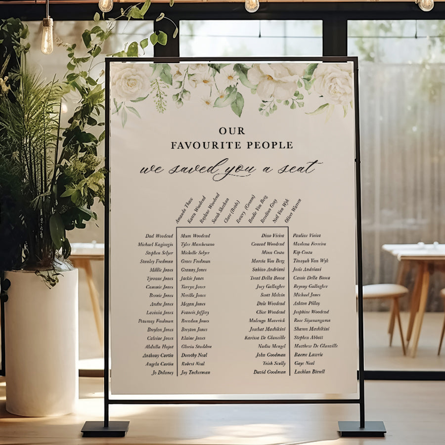 Wedding seating chart with white florals and calligraphy.Our favourite people we saved you a seat heading.