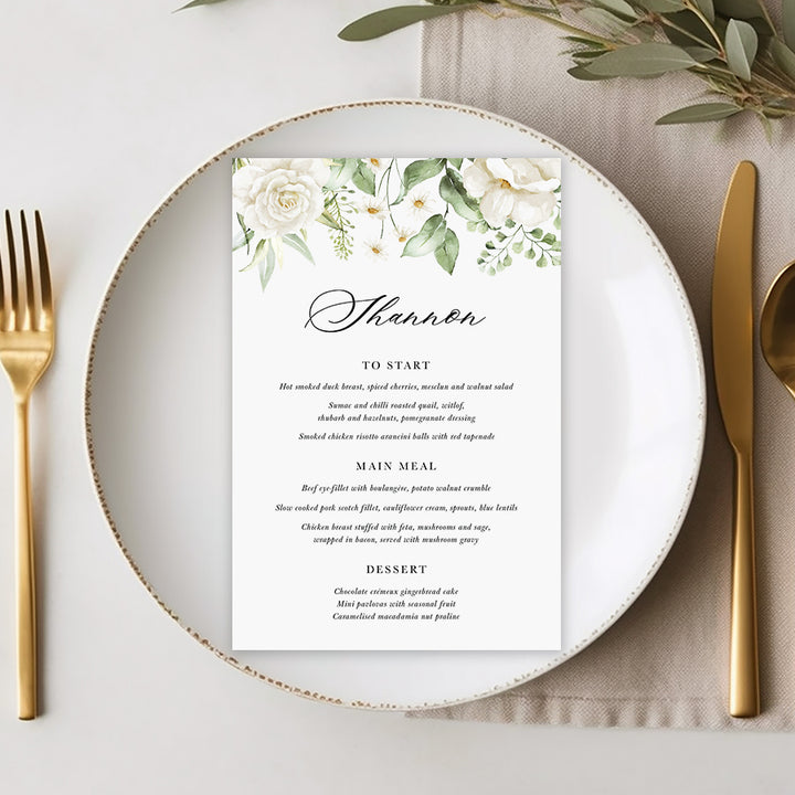 Wedding menu with white florals and green leaves with traditional calligraphy font, professionally printed in Australia.